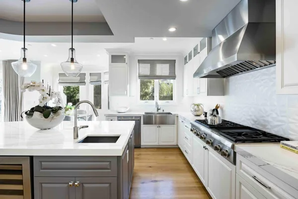 a kitchen with stainless steel appliances a white stove top oven a sink a counter space and wooden floor