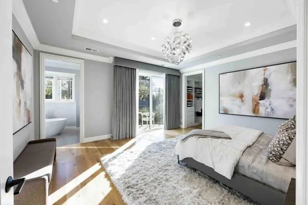 a spacious bedroom with a large bed and a chandelier