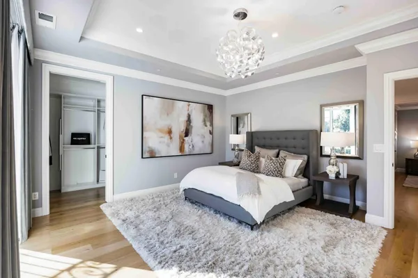 a bedroom with a large bed and a chandelier