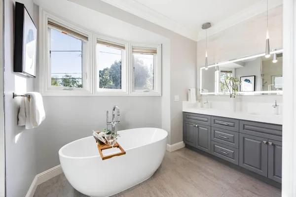 a bathroom with a tub sink and mirror
