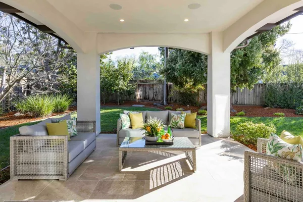 a view of a patio with couches table and chairs and potted plants