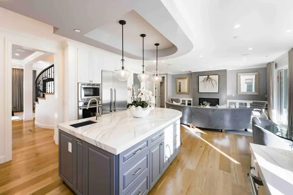 a large kitchen with kitchen island a large counter top space a sink stainless steel appliances and cabinets