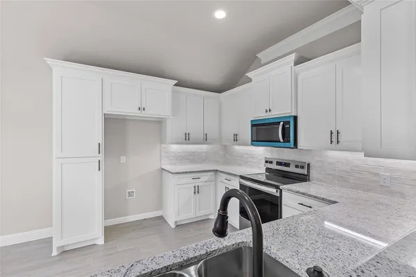 a kitchen with stainless steel appliances granite countertop a sink stove and cabinets