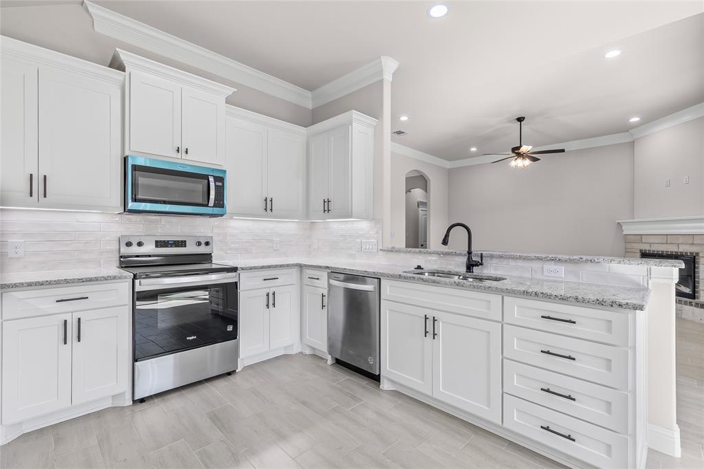 620 Jameson Springtown, TX 76082 - Photo 16 of 37 a kitchen with granite countertop white cabinets and stainless steel appliances