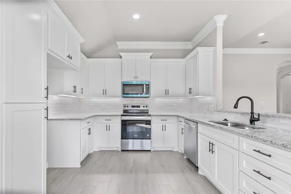 a kitchen with stainless steel appliances granite countertop a sink and cabinets