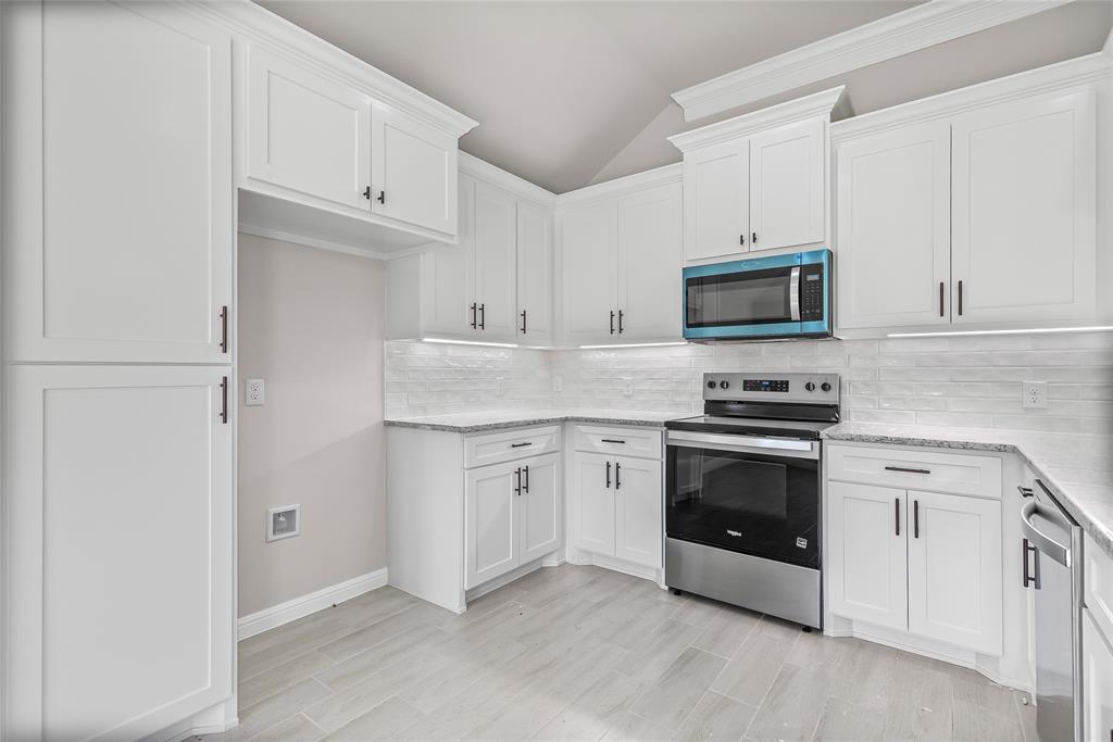 620 Jameson Springtown, TX 76082 - Photo 19 of 37 a kitchen with granite countertop white cabinets and stainless steel appliances