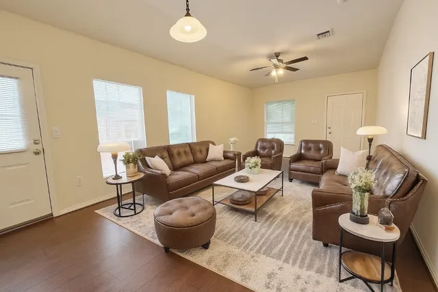 a living room with furniture and a wooden floor