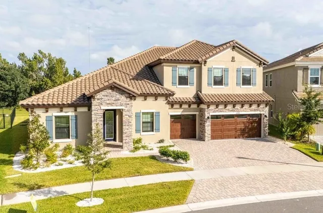 a view of a white house with large windows and plants