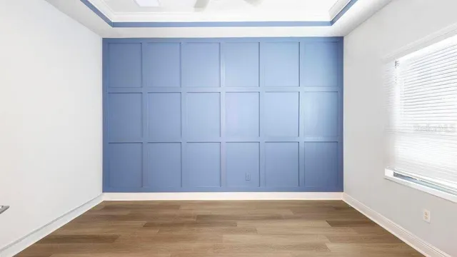 a view of an empty room with wooden floor with windows