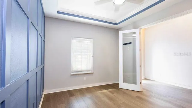 a view of empty room with wooden floor and window