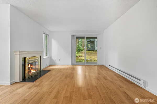 a view of an empty room with a fireplace and a window