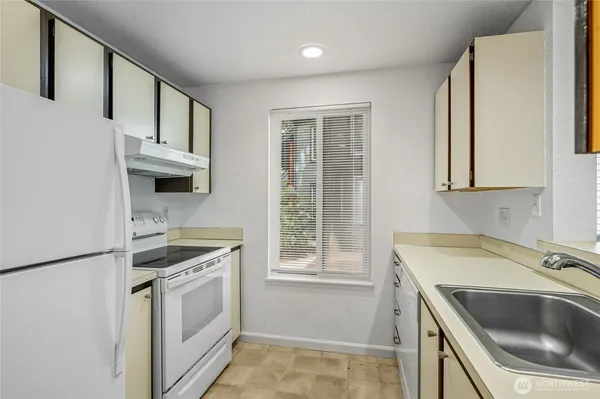 a kitchen that has a sink cabinets stainless steel appliances and a window