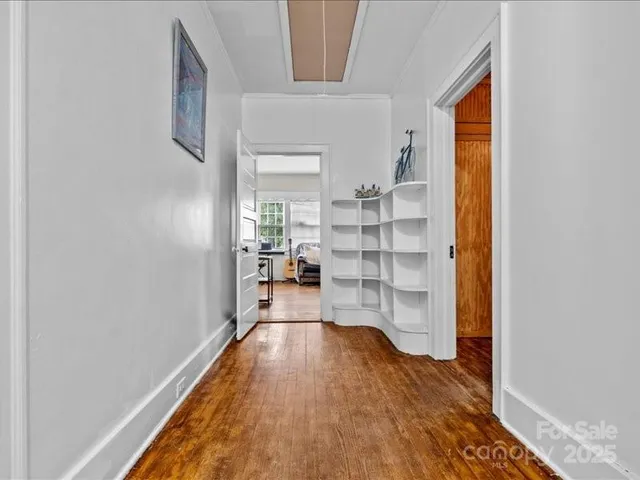 a view of a bedroom with wooden floor and windows