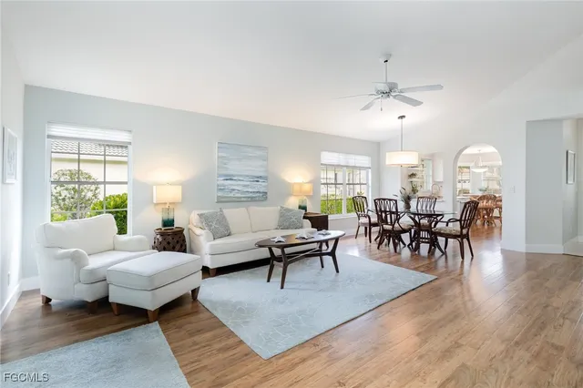 a living room with furniture dining table and a chandelier