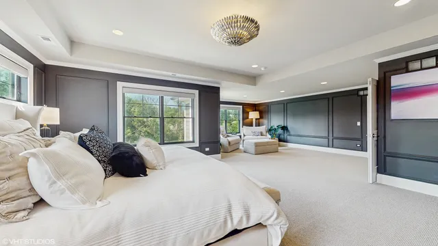 a bedroom with a large bed and a chandelier
