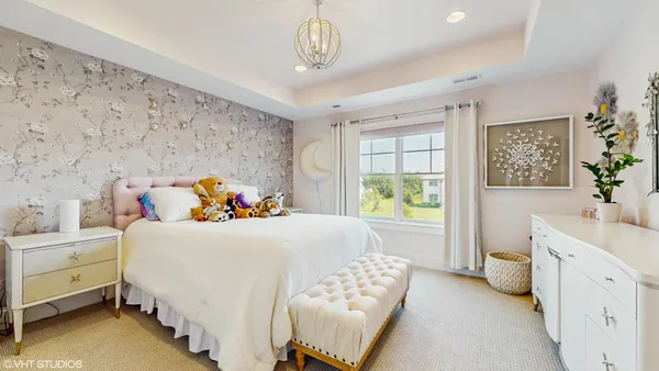 a bedroom with a bed a cabinets and next to a window