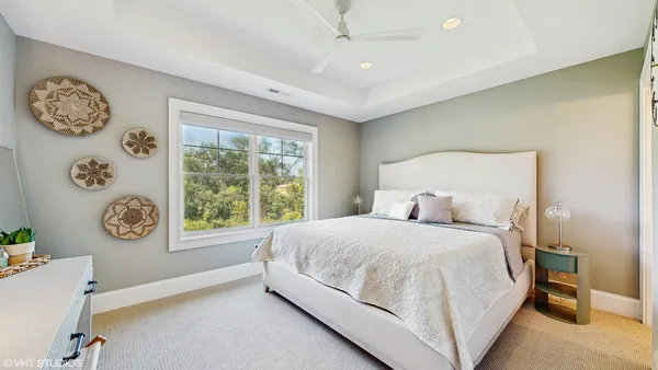 a bedroom with a bed window and a flat tv screen