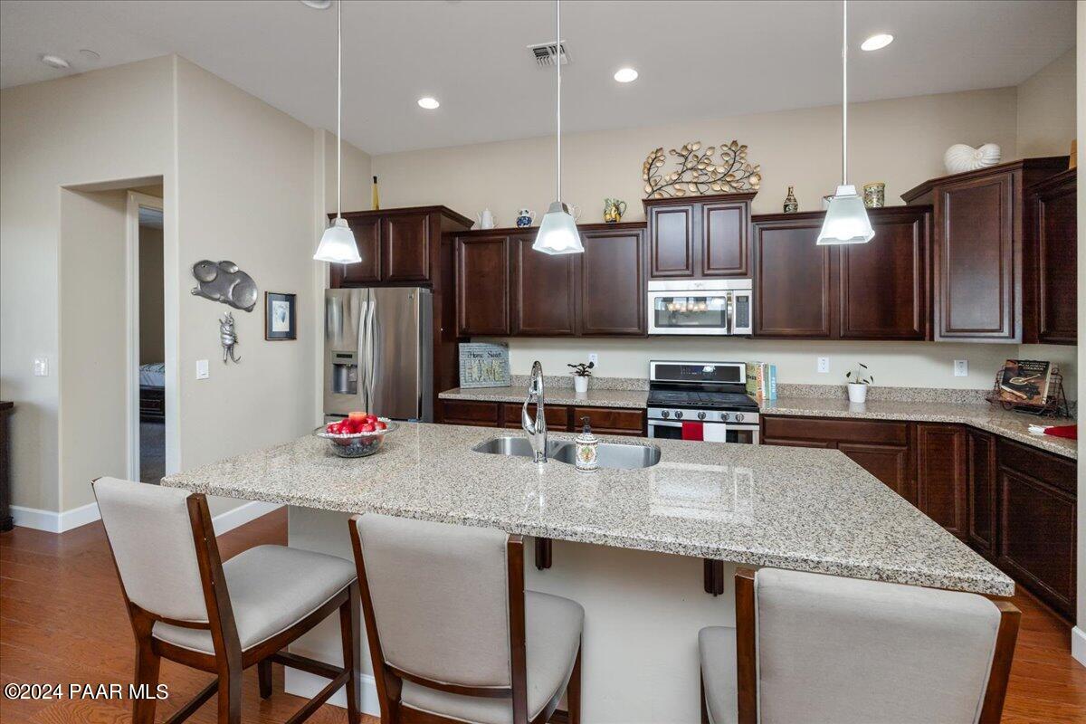 1478 Range View Circle Prescott Valley, AZ 86314 - Photo 6 of 31 a kitchen with stainless steel appliances granite countertop a sink refrigerator and chairs