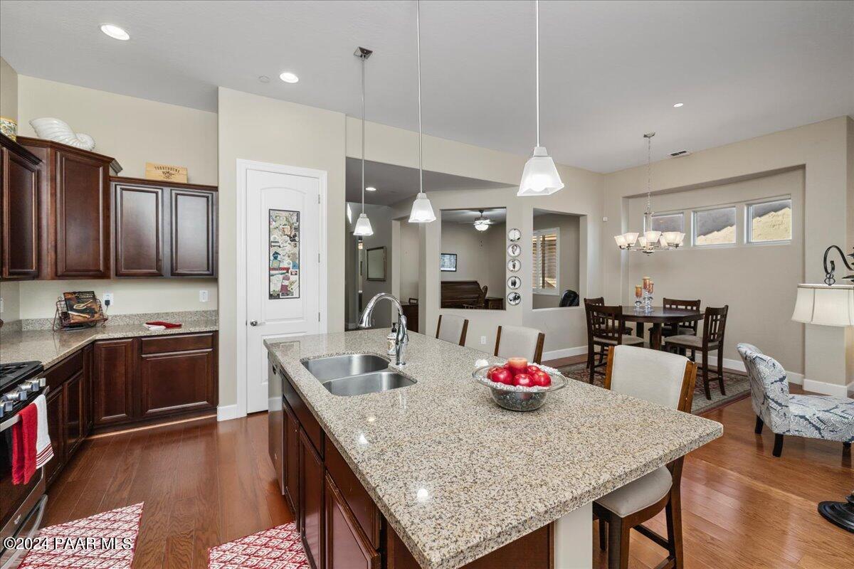 1478 Range View Circle Prescott Valley, AZ 86314 - Photo 8 of 31 a kitchen with granite countertop kitchen island stainless steel appliances sink refrigerator dining table and chairs