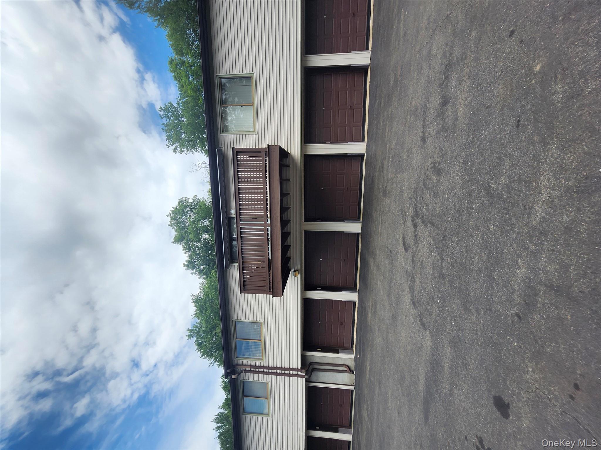 108 Village Road, Unit B Yorktown Heights, NY 10598 - Photo 17 of 42 a view of a house with a yard and a large tree