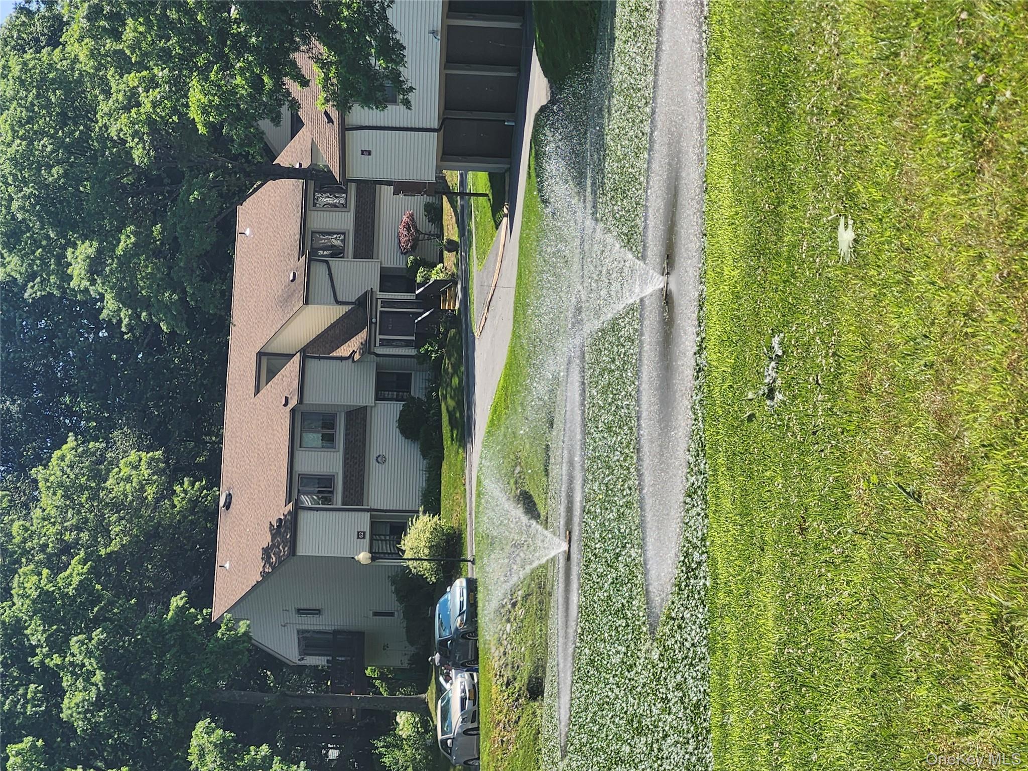 108 Village Road, Unit B Yorktown Heights, NY 10598 - Photo 18 of 42 View of front of property featuring a front yard, an attached garage, and driveway