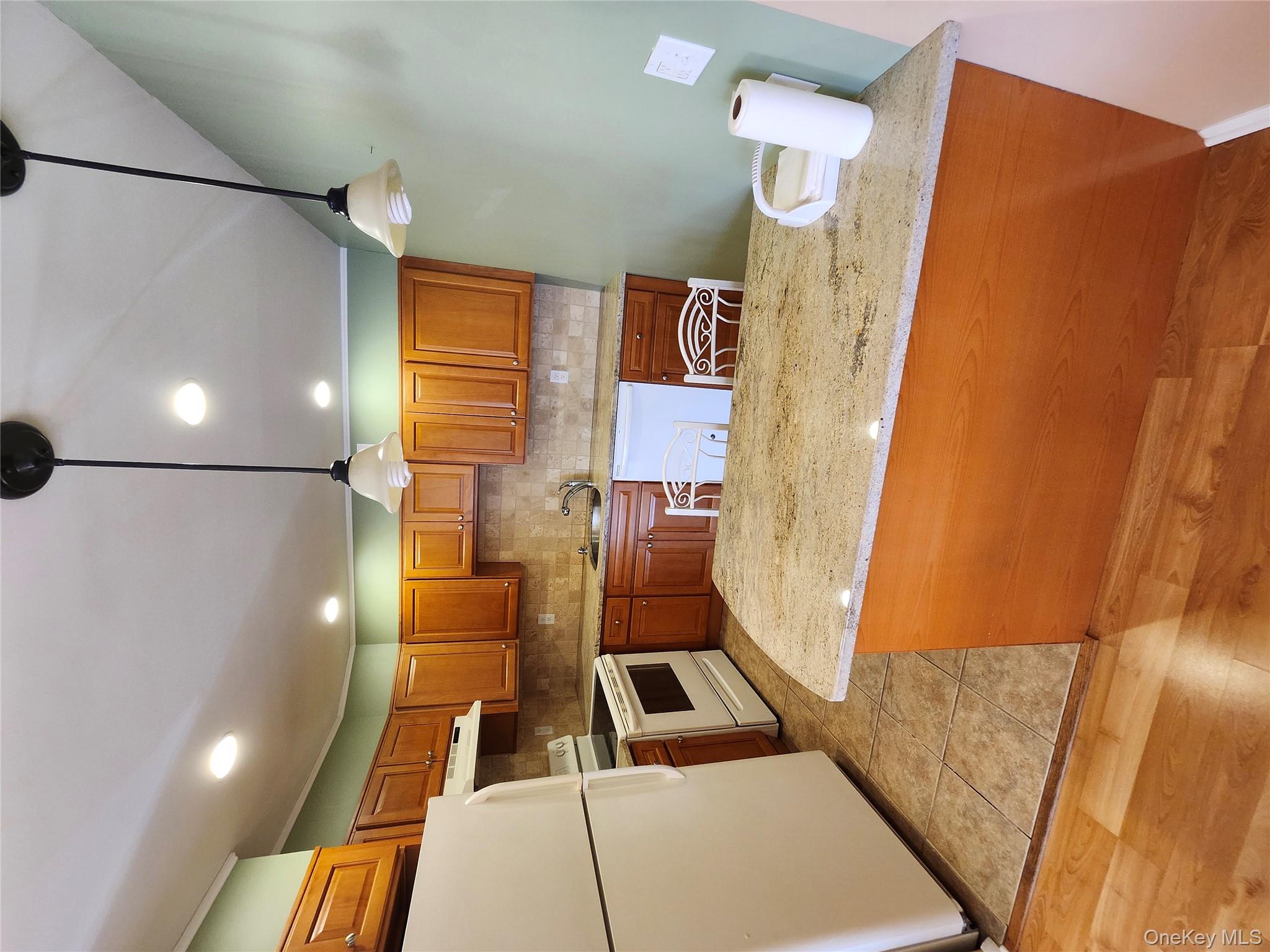 108 Village Road, Unit B Yorktown Heights, NY 10598 - Photo 28 of 42 Kitchen with backsplash, fridge, brown cabinetry, decorative light fixtures, and recessed lighting