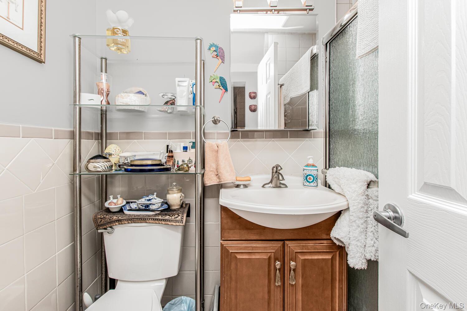 1110 Stadium Avenue, Unit 5F Bronx, NY 10465 - Photo 11 of 20 a bathroom with a sink a toilet and a mirror
