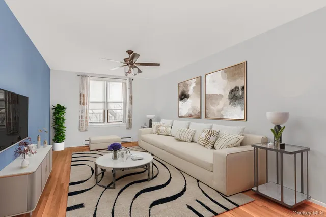 a living room with furniture a flat screen tv and a window