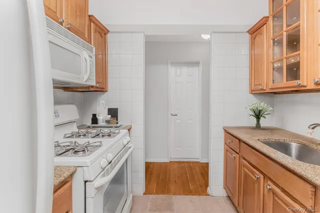 a kitchen with stainless steel appliances granite countertop a sink stove and cabinets