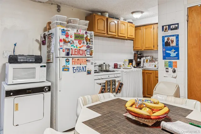 a room with stainless steel appliances kitchen island granite countertop furniture and a dining table