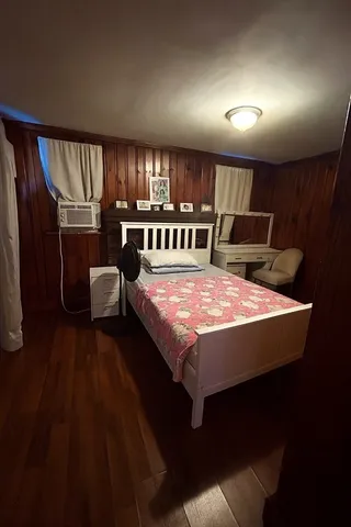 a large bedroom with a bed and wooden floor