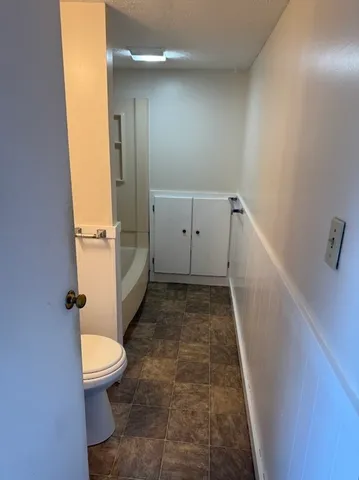 a bathroom with a sink a toilet a tub and shower