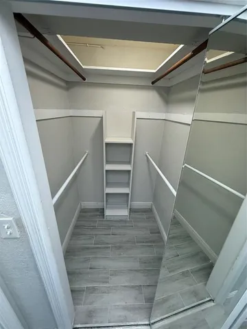 an empty room with wooden floor a ceiling fan and windows