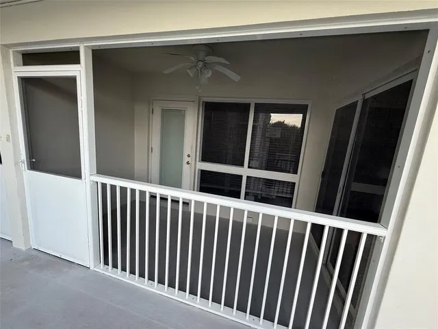 an empty room with windows closet and chandelier fan