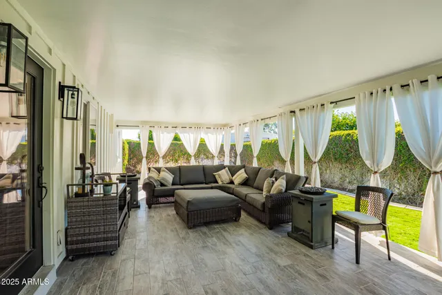a living room with furniture a lamp wooden floor and a large window