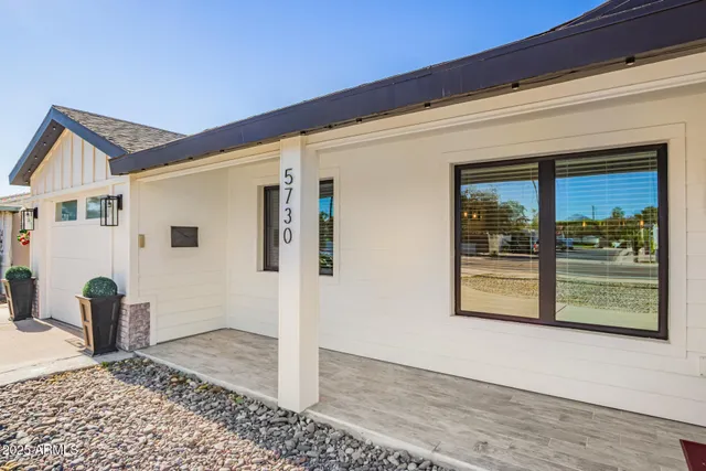 a view of a hallway with wooden floor and a living room