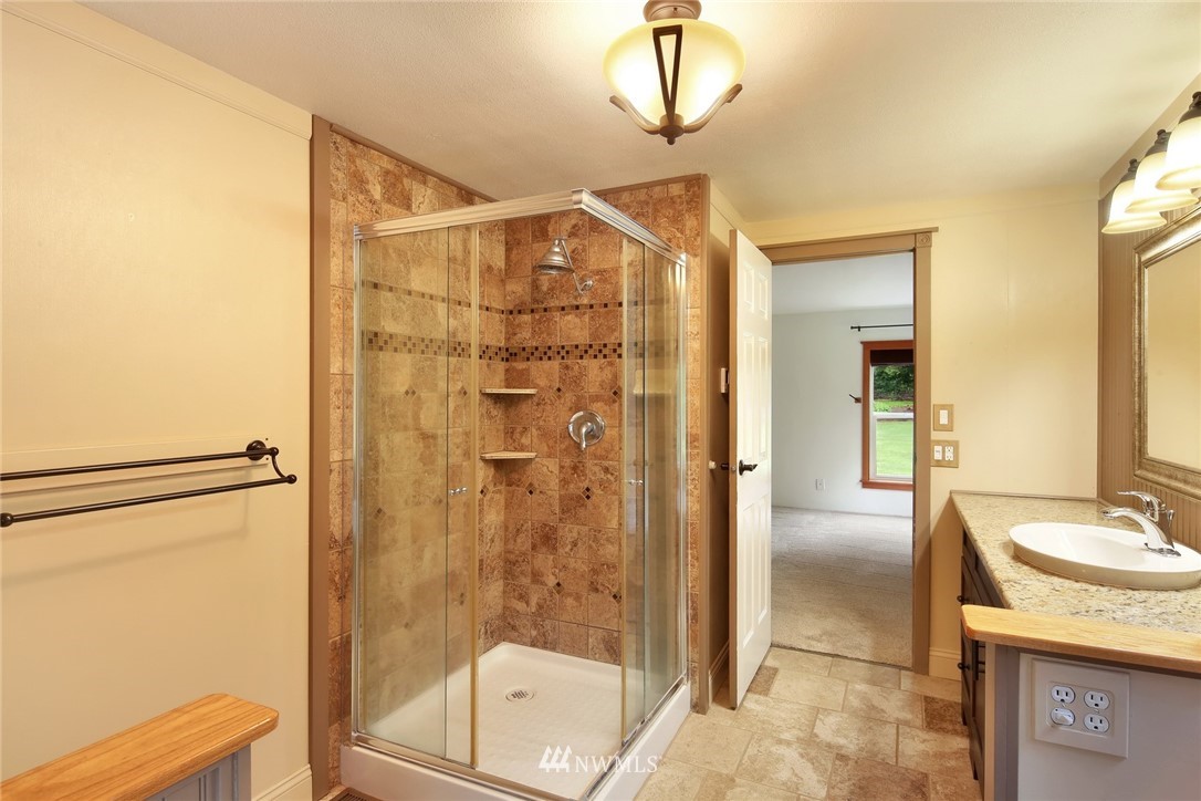 4030 Bay Road Ferndale, WA 98248 - Photo 13 of 36 a bathroom with a shower a sink and a mirror