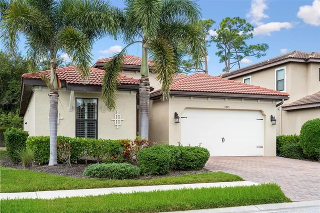 a front view of a house with a yard and potted plants