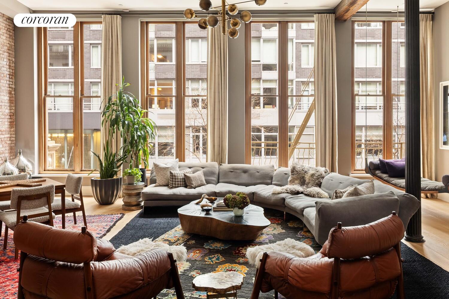 a living room with furniture and large windows