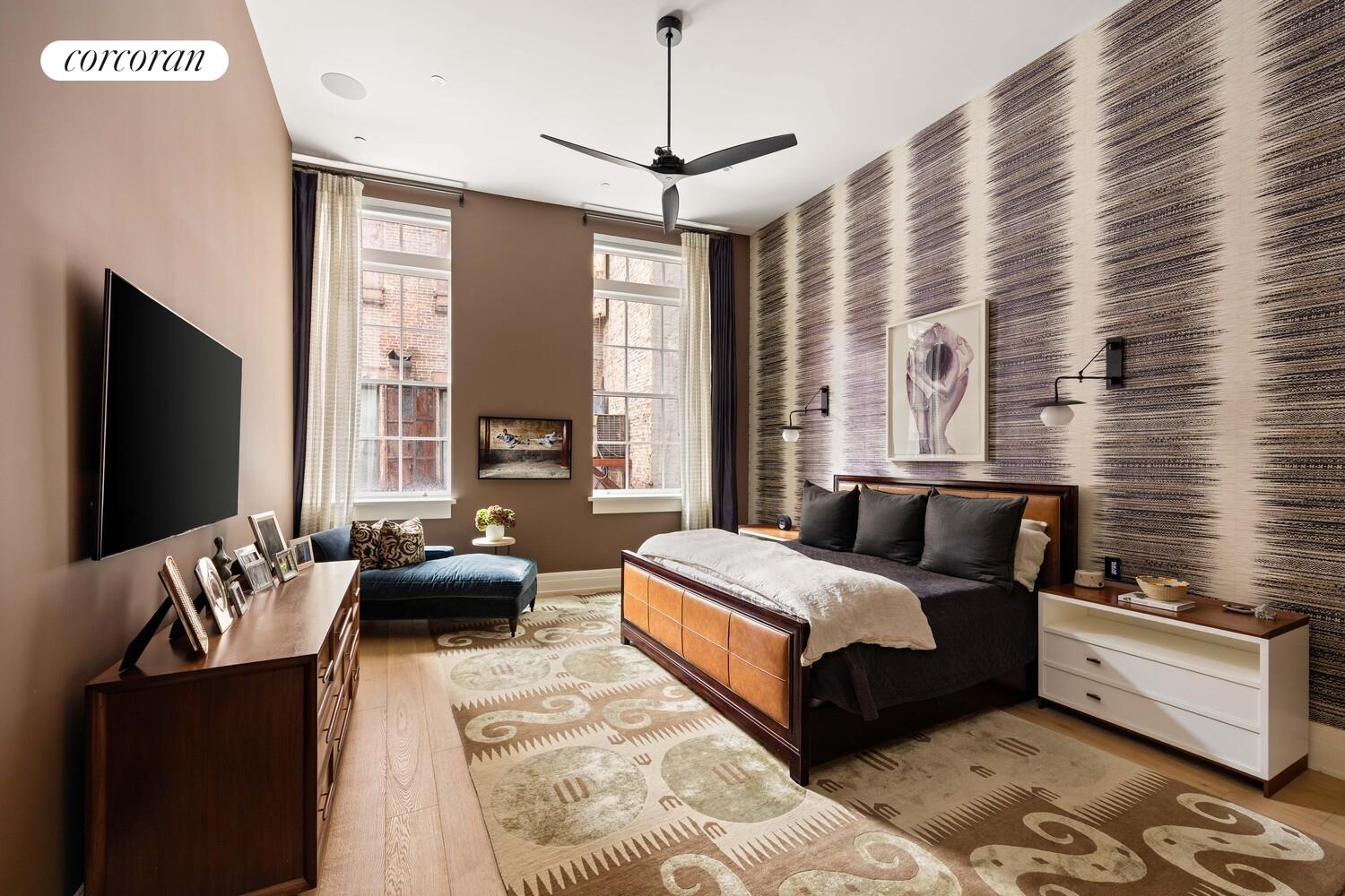 87 Leonard Street, Unit 2 Manhattan, NY 10013 - Photo 15 of 24 a spacious bedroom with a bed a couch and a flat tv screen