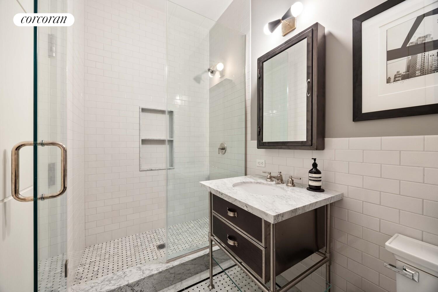 87 Leonard Street, Unit 2 Manhattan, NY 10013 - Photo 21 of 24 a bathroom with a sink and a mirror