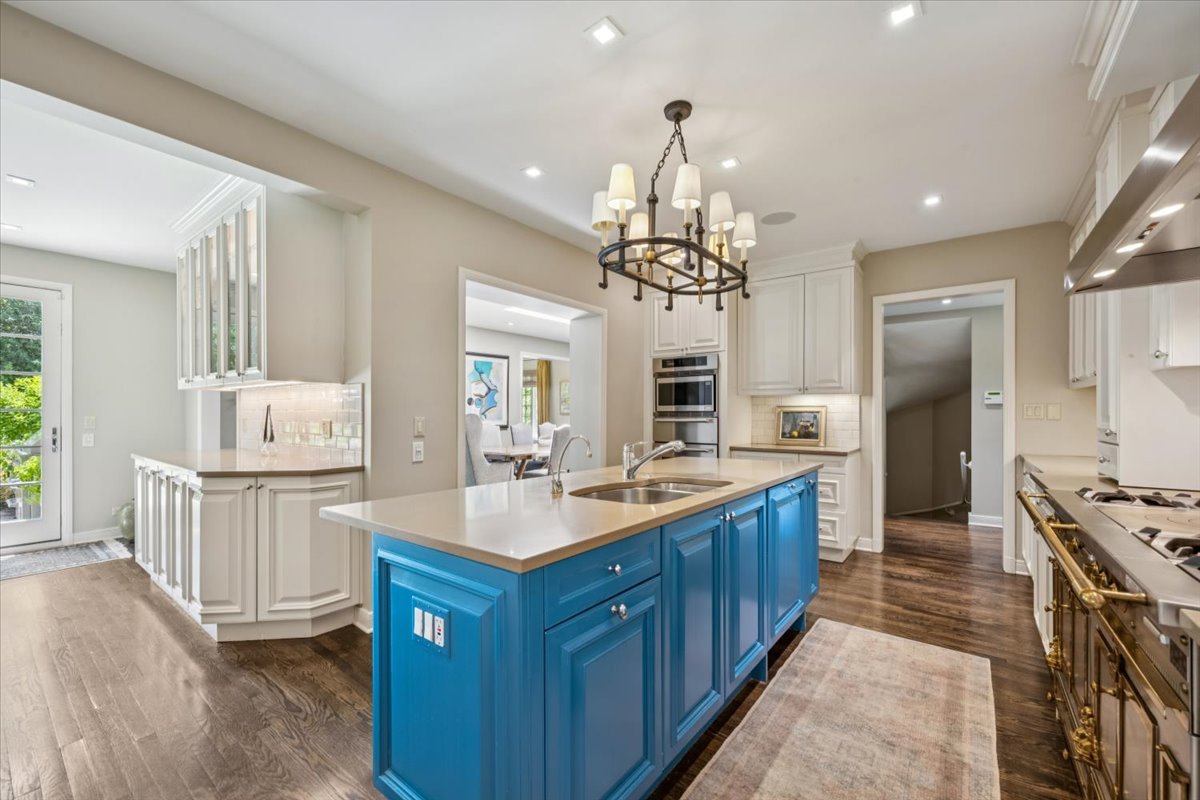 2311 Burr Oak Road Northfield, IL 60093 - Photo 17 of 69 a large kitchen with kitchen island a sink dishwasher a stove and a refrigerator with wooden floor