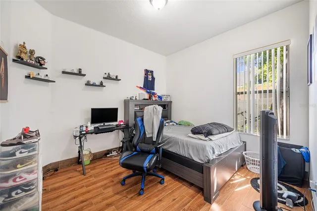 a bedroom with a bed and wooden floor