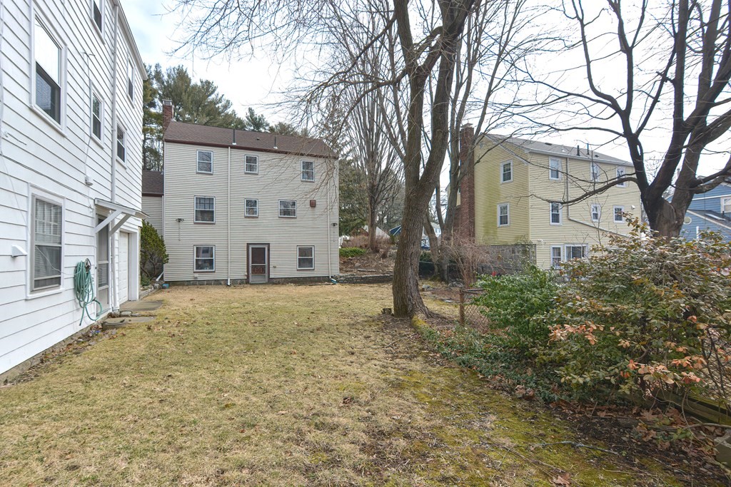 95 Southbourne Road Boston, MA 02130 - Photo 28 of 29 a view of a white house next to a yard with a large tree