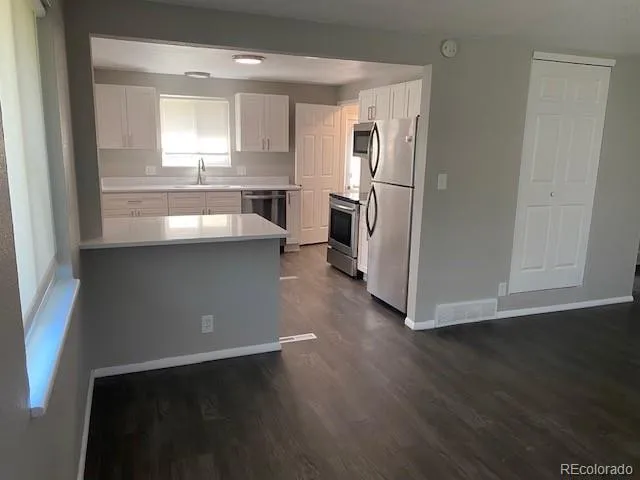 a kitchen with stainless steel appliances a refrigerator and a stove top oven