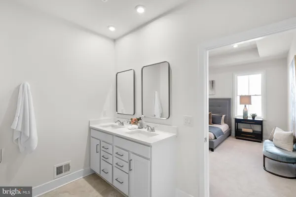 a spacious bathroom with double vanity and mirrors