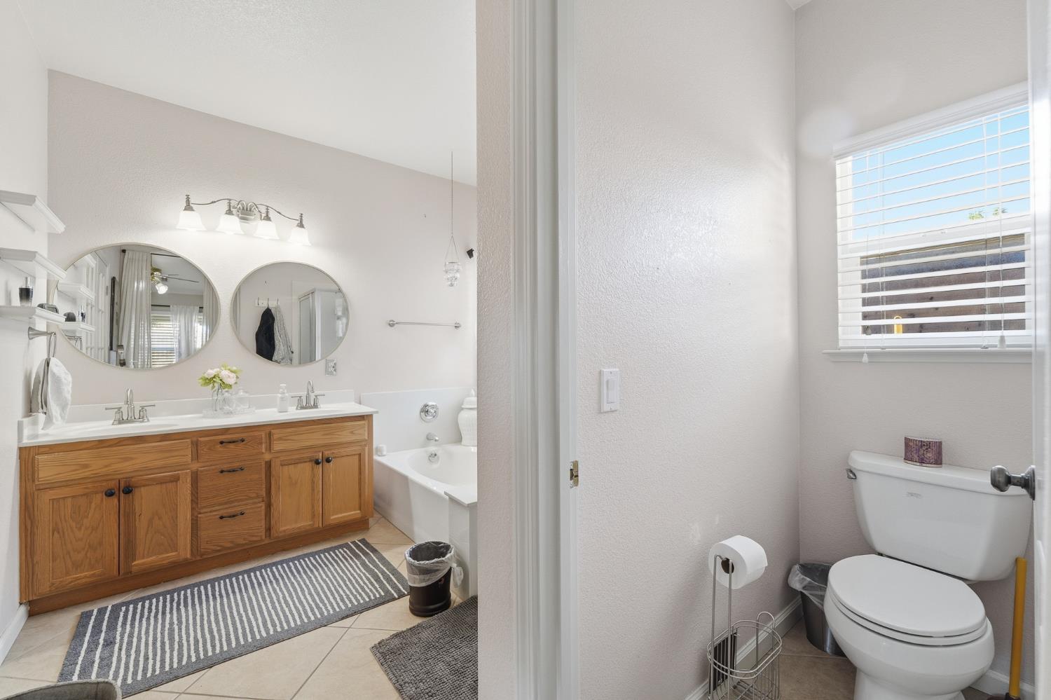 2220 Ellison Drive Modesto, CA 95355 - Photo 25 of 53 a spacious bathroom with a toilet a sink and a mirror