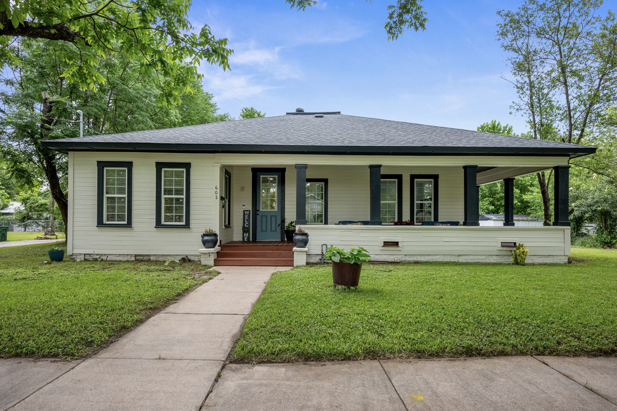 602 East 6th Street Cameron, TX 76520 - Photo 1 of 40 Single-story residence featuring a covered front porch with dark pillars, white siding, and a dark roof