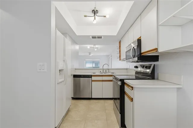 a kitchen with stainless steel appliances granite countertop a sink a stove a refrigerator and island