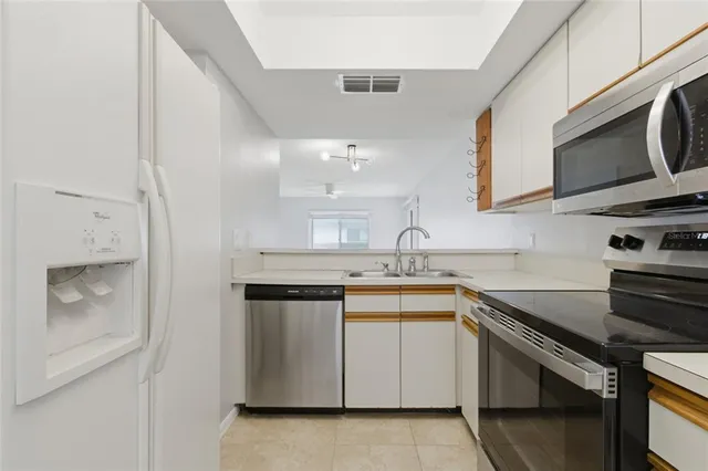 a kitchen with stainless steel appliances a sink stove and microwave